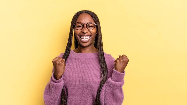 afro nero bella donna gridando trionfante, ridere e sentirsi felice ed eccitato mentre celebra il successo - Foto, immagini