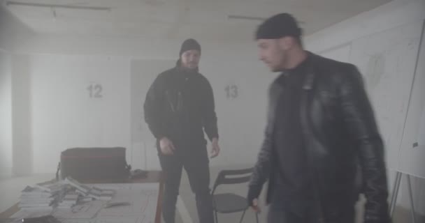 Two criminals planning bank job together in smoky garage - Footage, Video