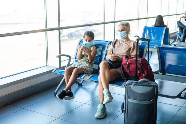 happy mother and daughter at airport travelling together - Photo, Image