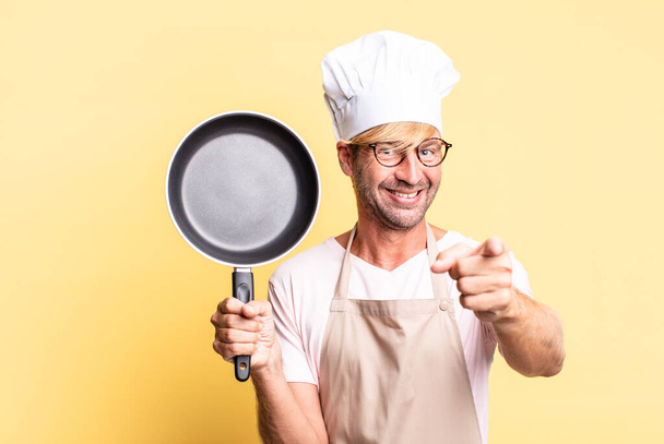 blonde handsome chef  adult man holding a pan - Fotografie, Obrázek