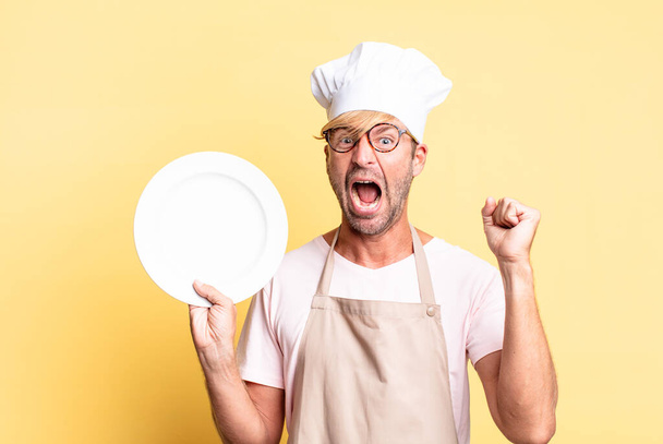 blonde handsome chef  adult man with an empty dish - Photo, Image