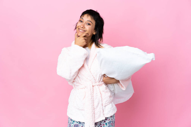 Young Uruguayan woman in pajamas over isolated pink background laughing - Photo, Image