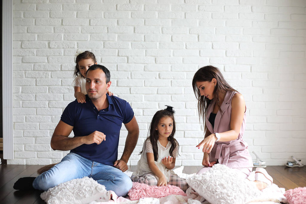 Hermosa familia joven con hijas en una sesión de fotos en un estudio blanco - Foto, Imagen