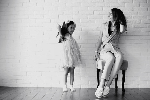 Beautiful young family with daughters at a photo shoot in a white studio - Foto, Imagen