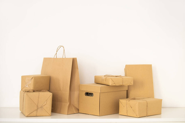 Craft papírové tašky a lepenky prázdné krabice předkládané na stole, izolované na bílém pozadí. - Fotografie, Obrázek