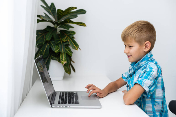 Хлопчик проводить відеоконференції з репетитором на ноутбуці вдома. Концепція дистанційної освіти
. - Фото, зображення
