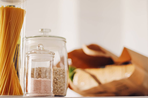 Food products in glass jars in the kitchen, pasta, cereal, salt, wine, groceries - Φωτογραφία, εικόνα