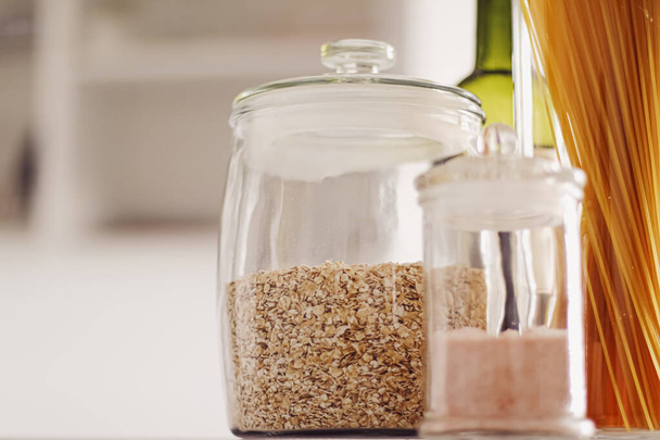 Food products in glass jars in the kitchen, pasta, cereal, salt, wine, groceries - Photo, Image