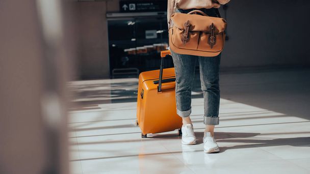 Крупним планом туристичний турист з багажем або валізою в терміналі аеропорту
. - Фото, зображення