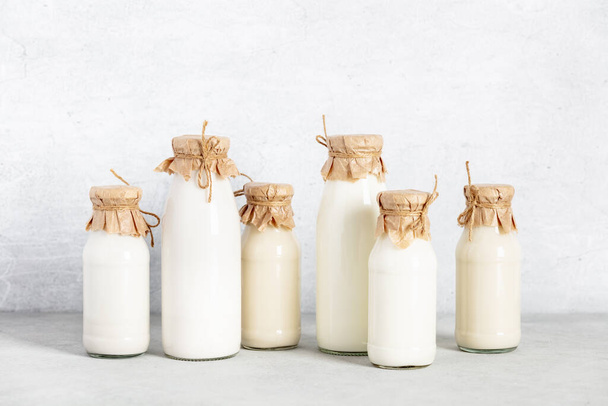 Non dairy plant based milk in bottles and ingredients on light background. Alternative lactose free milk substitute - Foto, imagen
