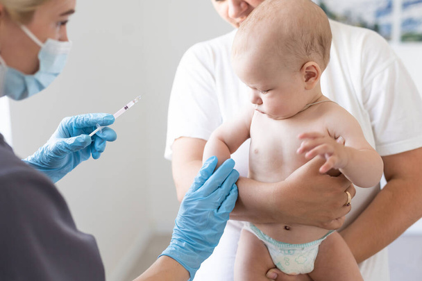 Il medico fa una vaccinazione per bambini su sfondo bianco. - Foto, immagini