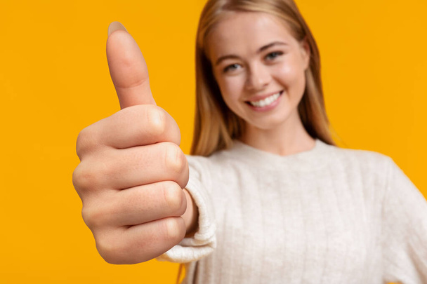 Χαριτωμένο κορίτσι έφηβος δείχνει μεγάλο δάχτυλο επάνω στο κίτρινο - Φωτογραφία, εικόνα