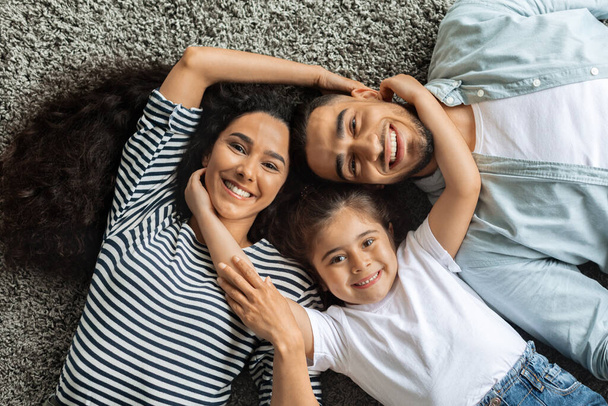 Крупный план счастливой ближневосточной семьи, обнимающейся на полу - Фото, изображение