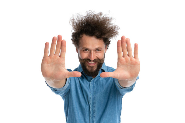 bonito casual homem mostrando suas palmas para o câmara e sorrindo no branco fundo - Foto, Imagem