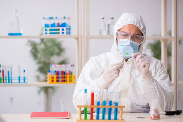 Young male chemist in drugs synthesis concept - Foto, Bild