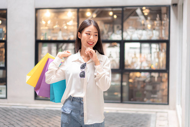 Portrait of Asian girl excited beautiful girl happy smiling with holding shopping bags relaxed expression, Positive emotions shopping, lifestyle concept. - Valokuva, kuva