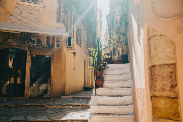Corfu, Greece - September 2021. Beautiful cozy narrow street in old town of Kerkyra. Historic european facade with stairs. Cityscape concept. - Fotoğraf, Görsel