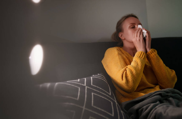 Sick woman in bed in living room. - Foto, Imagen
