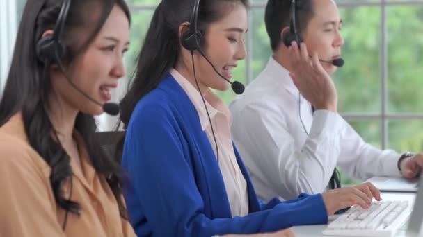 Pessoas de negócios usando fone de ouvido trabalhando ativamente no escritório - Filmagem, Vídeo