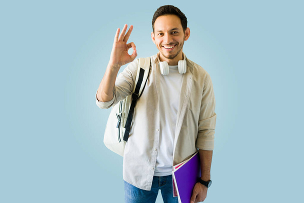 Everything is perfect. Good-looking hispanic university student making the ok perfect gesture  - Photo, Image