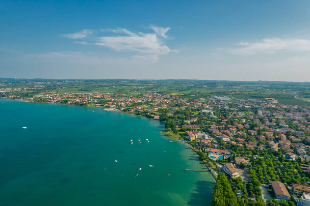 Uitzicht vanuit de lucht op de kustlijn van Sirmione resort in Italië - Foto, afbeelding