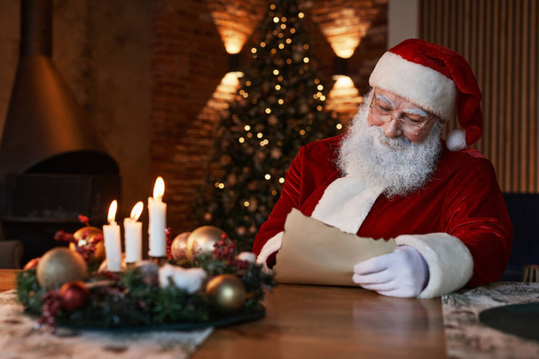 Santa Reading Letter At Table - Photo, Image