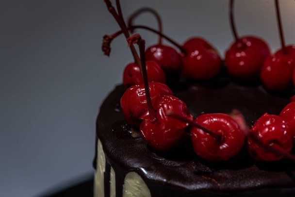 Chocolate cake with cherries on a light background. Cooking and sweets concept - Foto, afbeelding