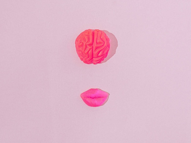 Neon roze menselijke hersenen en lippen. Surrealistisch menselijk gezicht creatief concept. Futuristische kunstzinnige visie van mooie slimme vrouwen. - Foto, afbeelding