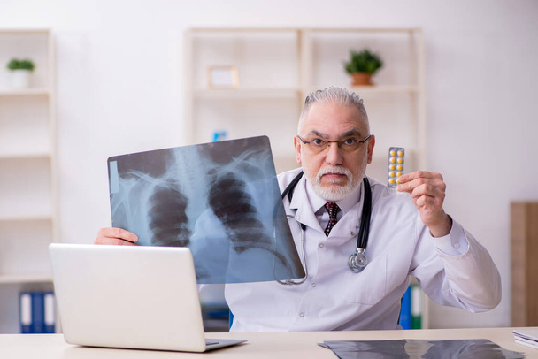 Old male doctor radiologist working in the clinic - Photo, image