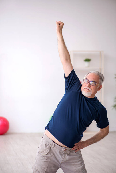 Starý muž dělá sportovní cvičení uvnitř - Fotografie, Obrázek