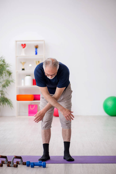 Vieil homme faisant des exercices de sport à l'intérieur - Photo, image