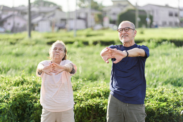 Personas mayores haciendo ejercicios preparatorios afuera - Foto, imagen