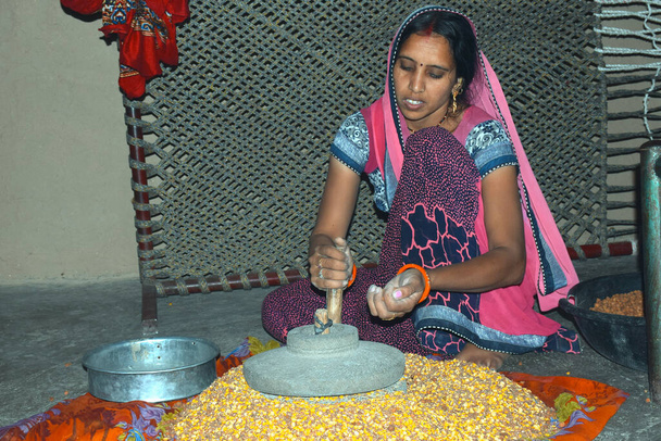 Wiejska kobieta mieli gram w starej młynie mąki obsługiwanej ręcznie - Zdjęcie, obraz