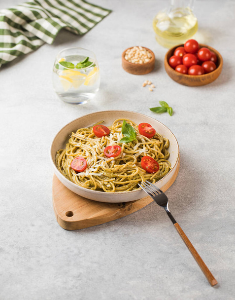 Spaghetti pasta with pesto sauce and cherry tomatoes on a plate. Menu, Italian cuisine. - Foto, immagini
