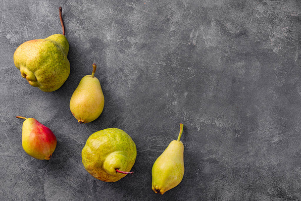 Several ripe pears on gray background top view, trending ugly fruits. High quality photo - 写真・画像