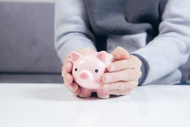 a man holding a piggy bank - 写真・画像
