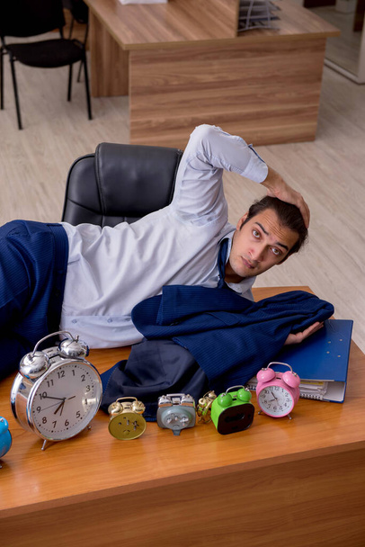 Joven empleado masculino durmiendo en la oficina en la gestión del tiempo co - Foto, Imagen