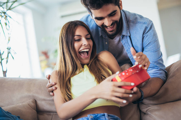 Man giving a surprise gift to woman at home - Photo, Image