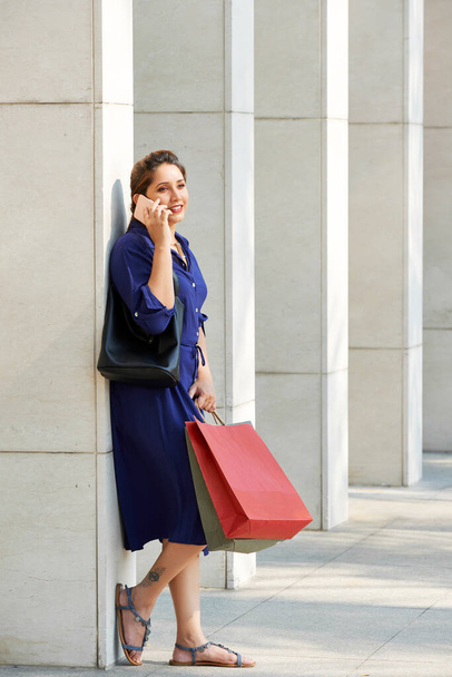 ショッピングバッグ付きの魅力的な女性 - 写真・画像