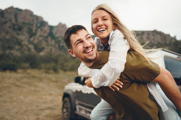 Young couple is on romantic trip to the mountains by car - Фото, изображение