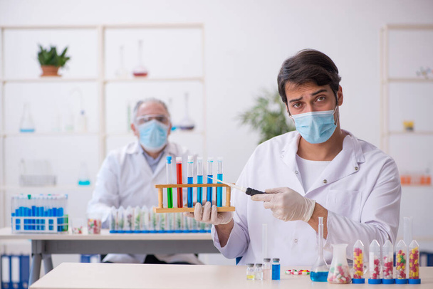 Δύο άνδρες χημικοί στην έννοια της σύνθεσης φαρμάκων στο εργαστήριο - Φωτογραφία, εικόνα