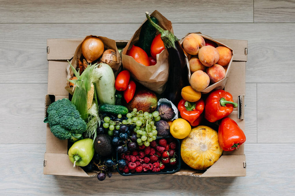 Bir kutu taze organik sebze, meyve ve böğürtlen. Yiyecek teslimatı kavramı. - Fotoğraf, Görsel