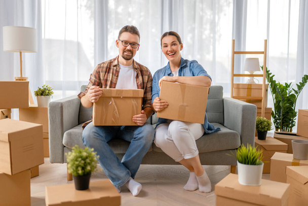 Happy young married couple are moving to new apartment. - Фото, изображение