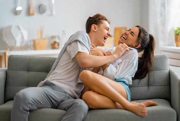 Portrait of cheerful young couple having fun and hugging at home. - Fotoğraf, Görsel