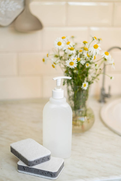 Eco friendly non-toxic cleaning dish soap with chamomile flowers, clean white plates . High quality photo - Foto, Imagem