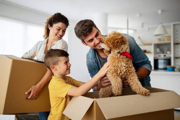 Happy young family with cardboard boxes in new house at moving day. - Foto, Imagem