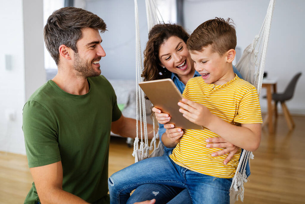 Happy family using technology devices together at home. People, education concept. - Photo, Image
