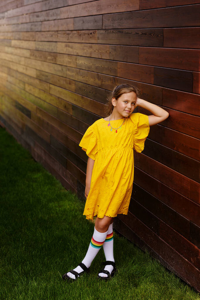 pretty and fashion child girl near the wooden wall - Foto, Imagem