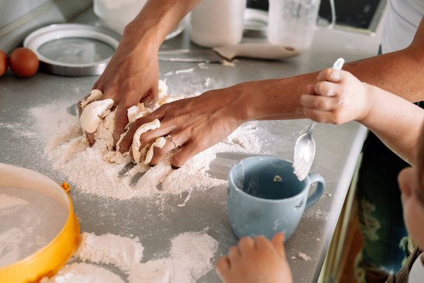 Top view table with hands of  mother and little daughter preparing dough for ginger cookies on kitchen. Happy family, cozy apartments. - Photo, image