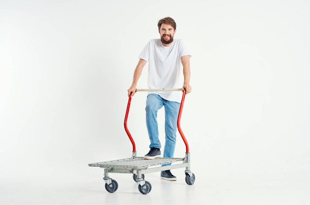Hombre alegre en un transporte de camiseta blanca en un fondo claro caja - Foto, imagen